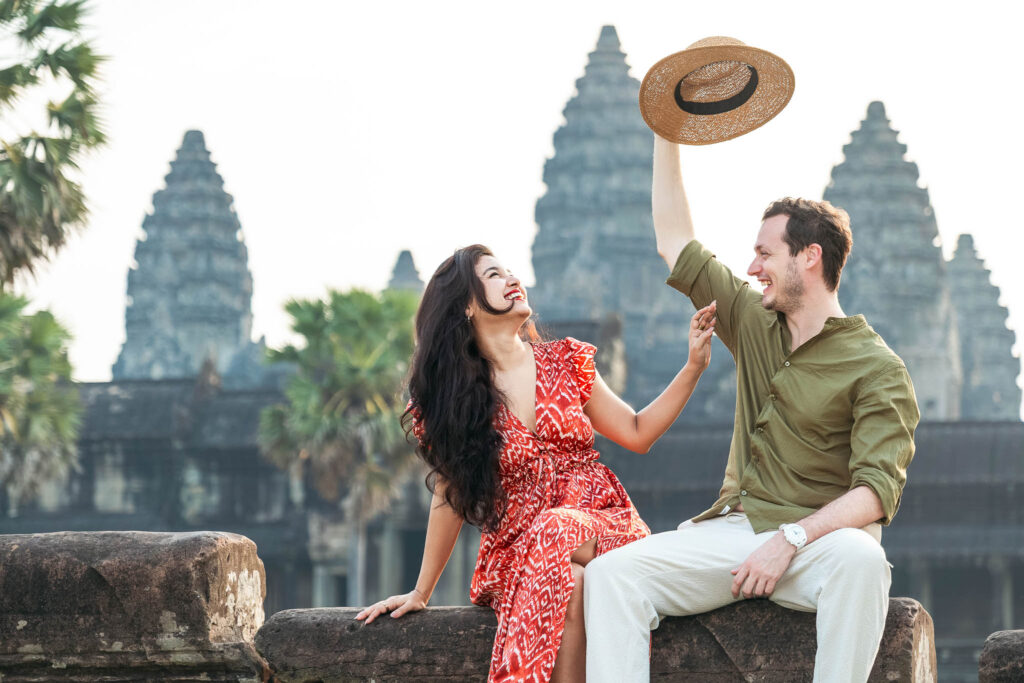 Romantic Angkor Wat photoshoot with couple sitting at temple ruins in Siem Reap